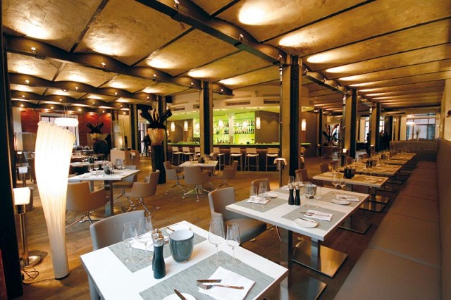 "Das trendige Restaurant VLET zeigt sich in dem eleganten Design aus roten Backsteinen, grüner Bar und offenen Stahlträgern von JOI-Design."